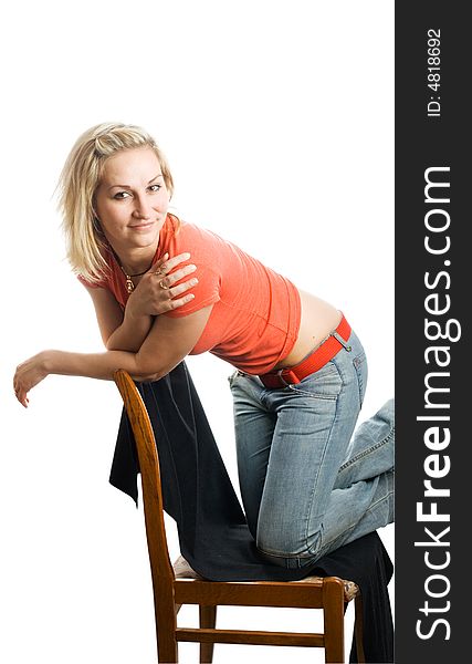 Girl in red t-shirt and blue jeans on the chair. Isolated.