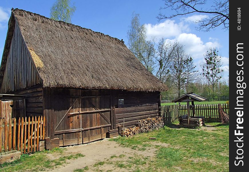 Old wooden hut in village, green grass around