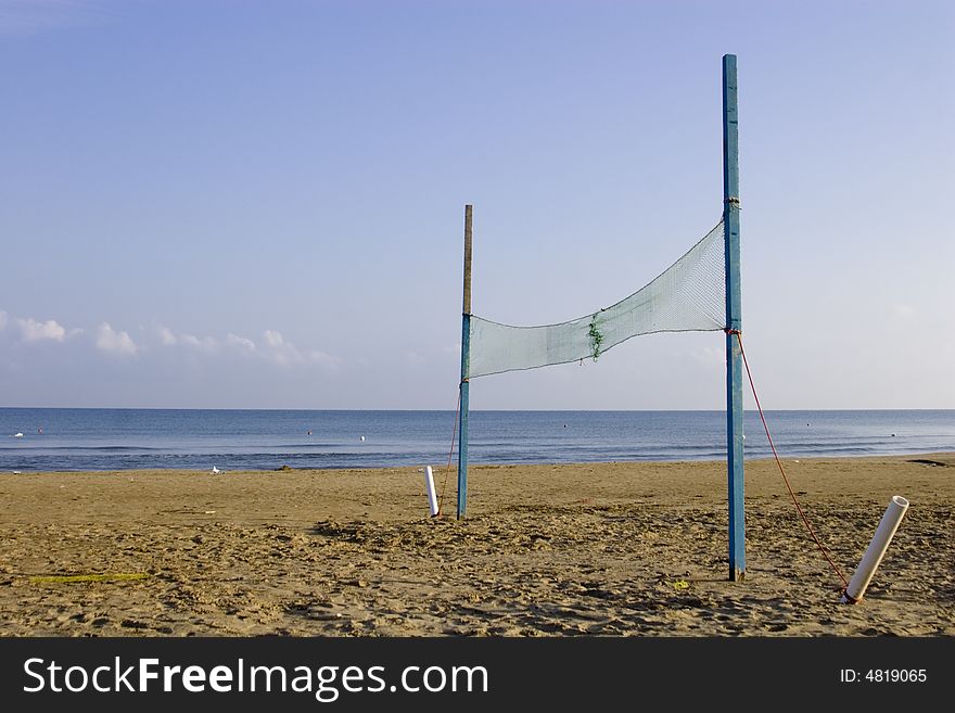 View of an empty beach and volleyball net. View of an empty beach and volleyball net