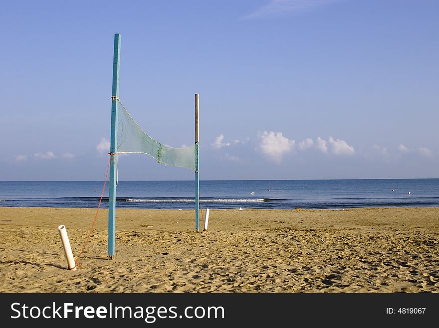 View of an empty beach and volleyball net. View of an empty beach and volleyball net