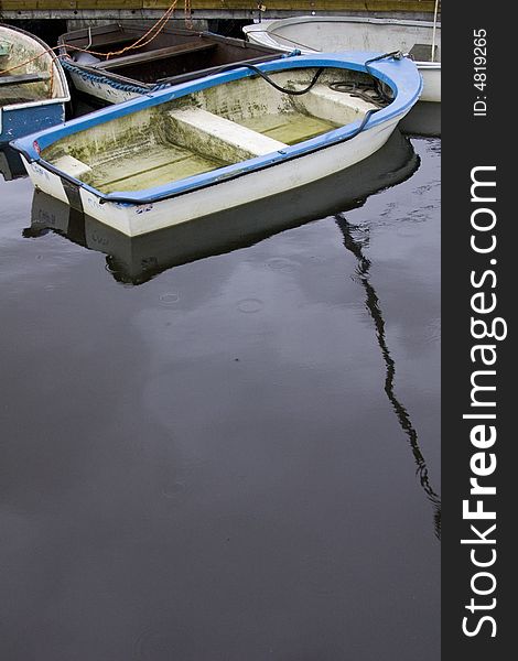 Blue dinghy rowing boat mored on the quayside in Lymington