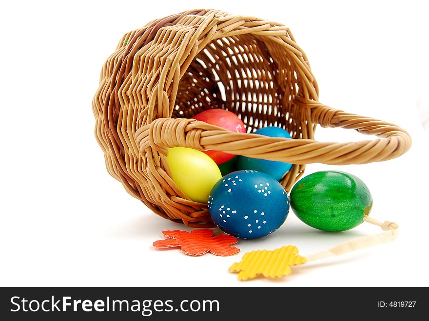 Basket of easter eggs on white background and paper flowers