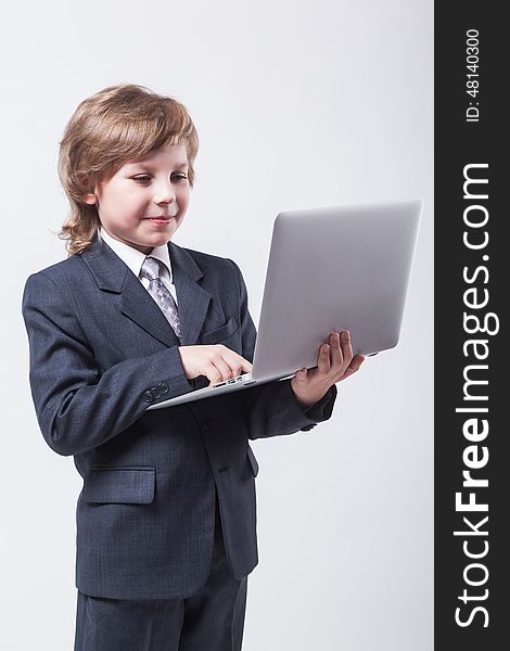 An ambitious young man in shirt and tie with a laptop and looking at the camera