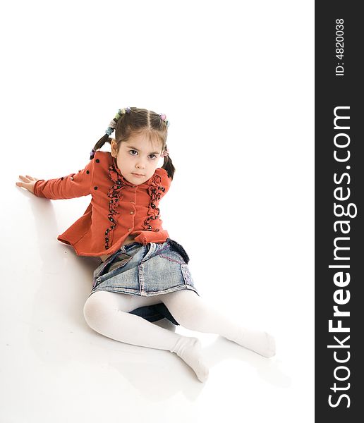 The little sitting girl isolated on a white background