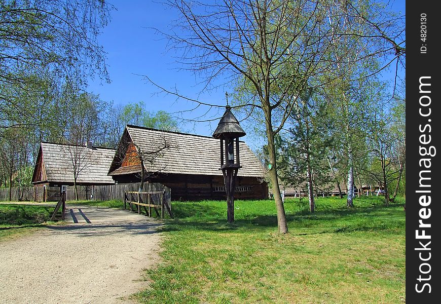 Old wooden hut in village, green grass around