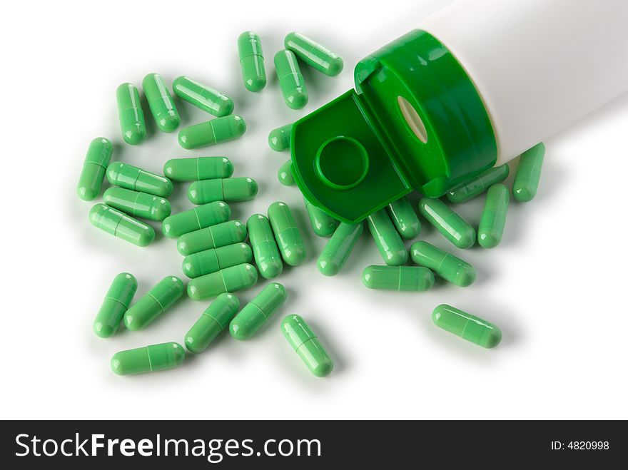 Green pills and bottle, isolated on white with shadow. Green pills and bottle, isolated on white with shadow