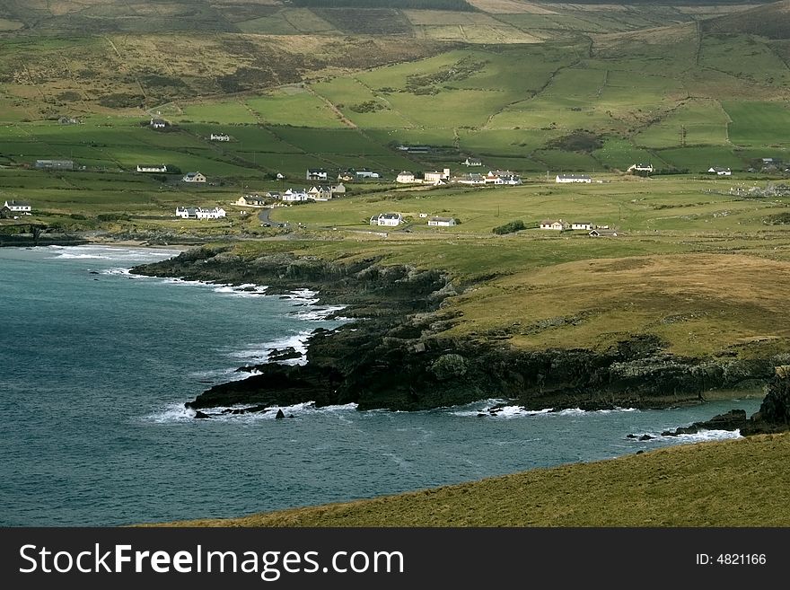 Rocky coastline with fields and mountains in Southern Ireland. Rocky coastline with fields and mountains in Southern Ireland