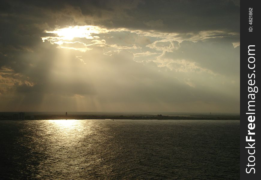 Island of Cozumel in Mexico. Clouds partially cover the sun. View from the water. Island of Cozumel in Mexico. Clouds partially cover the sun. View from the water.