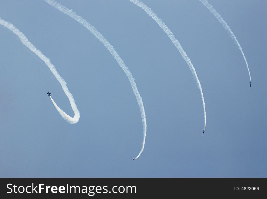 Four jets with white smoke traces in the blue sky. Four jets with white smoke traces in the blue sky.