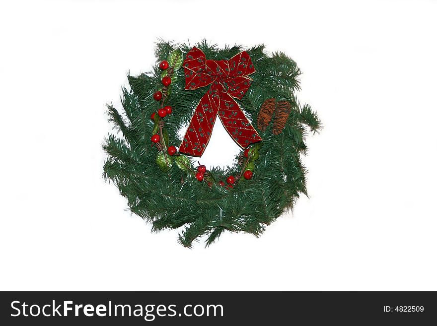 Red and green holiday wreath hanging on a white background