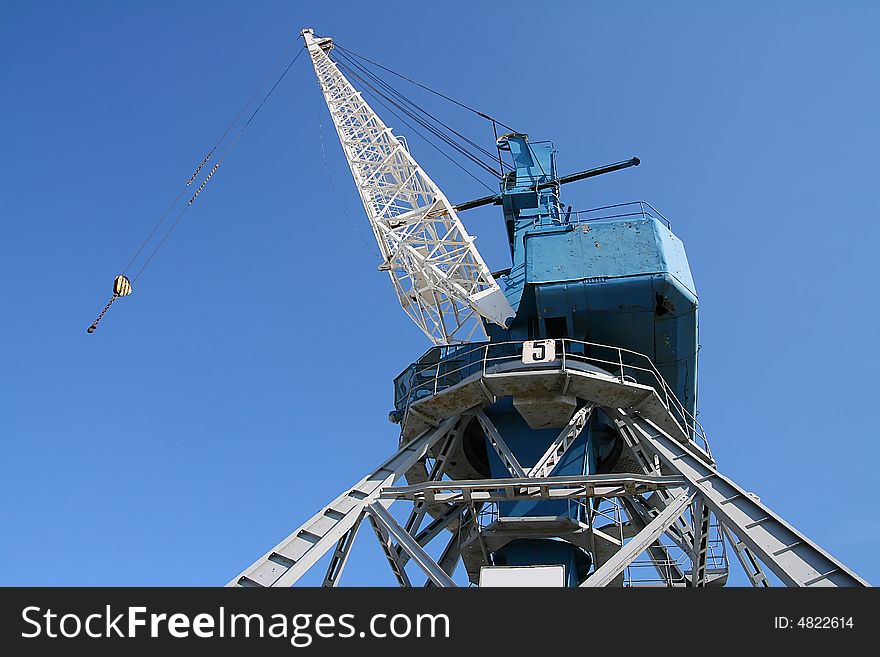 Huge port crane on isolated blue background. Huge port crane on isolated blue background.