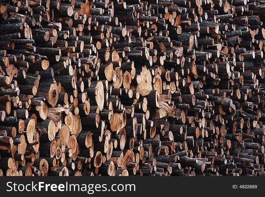 A heap of raw brown and yellow firewoods.