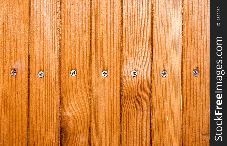 Brown planks with screw heads screwed in wooden wall. Brown planks with screw heads screwed in wooden wall.