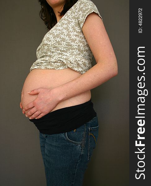 A pregnant woman is holding her belly