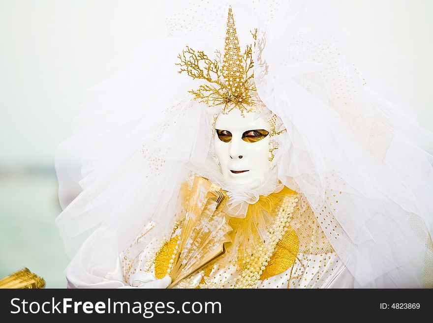 Gold and white costume at the Venice Carnival. Gold and white costume at the Venice Carnival