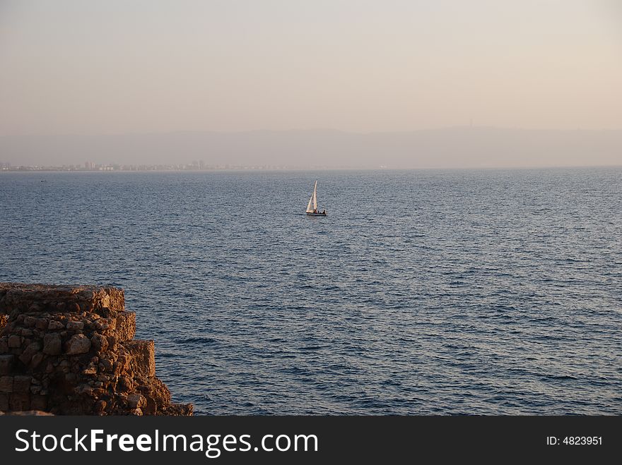 Lonely sailing vessel in the evening sea. Lonely sailing vessel in the evening sea