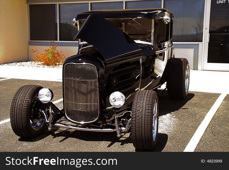 A classic black hotrod shines in the sunlight