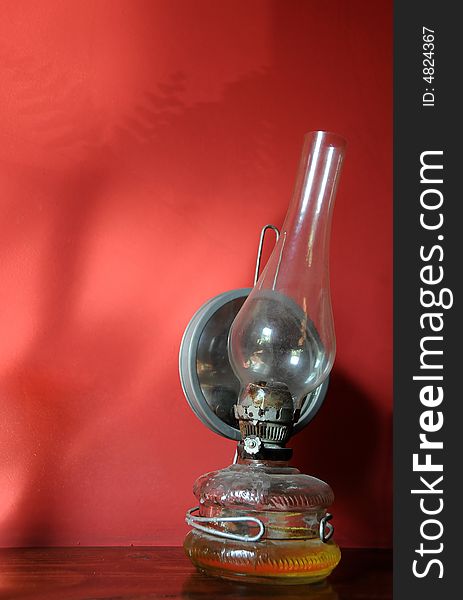 Old oil lamp on a red background