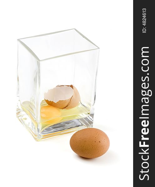 Cracked chicken egg with the yolk in a glass vase. Cracked chicken egg with the yolk in a glass vase