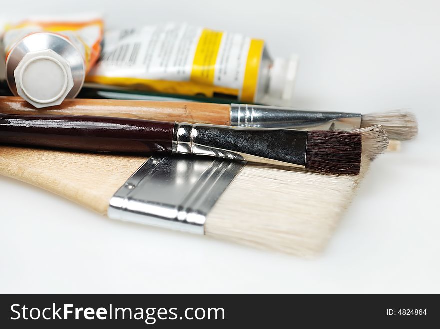 Different sizes of paint brushes with paint tubes
