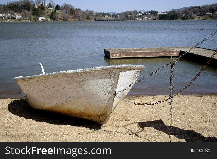 A boat securely tied on the beach of a lake. A boat securely tied on the beach of a lake