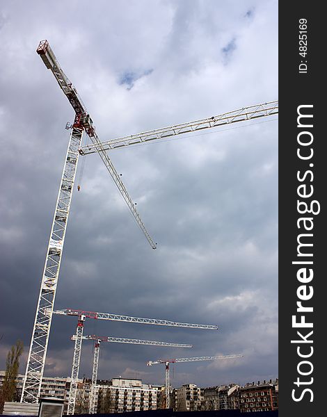 Construction cranes and clouds over an area. Construction cranes and clouds over an area