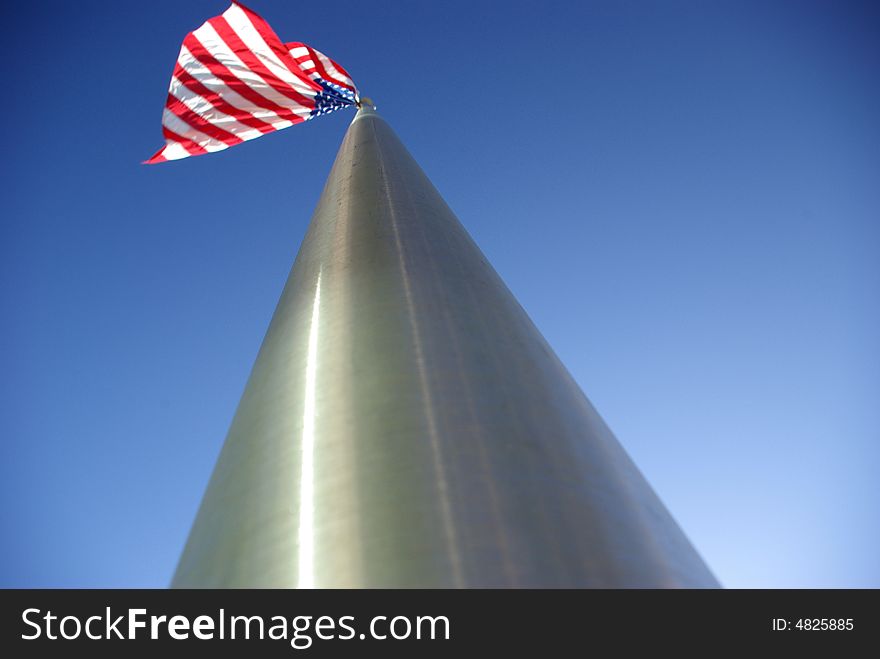 A unique view of a large American flag flying from the top of an aluminim flagpole. A unique view of a large American flag flying from the top of an aluminim flagpole.