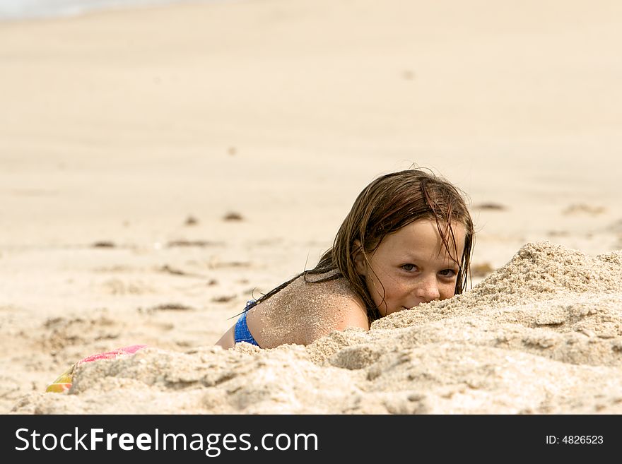 Young girl playing on the beach in the sand shot with shallow DOF. Young girl playing on the beach in the sand shot with shallow DOF