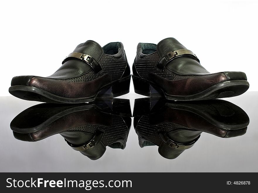 A man leather shoe with reflection and white background