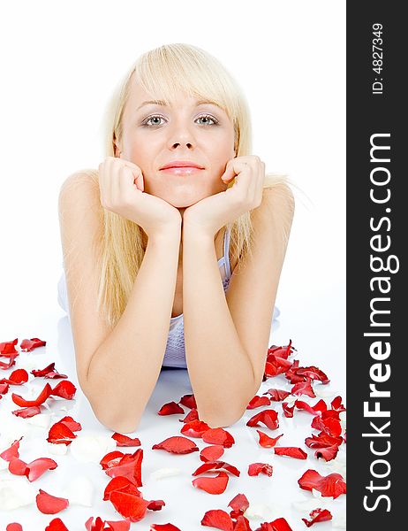 Beautiful young woman with green eyes posing on red rose petal field