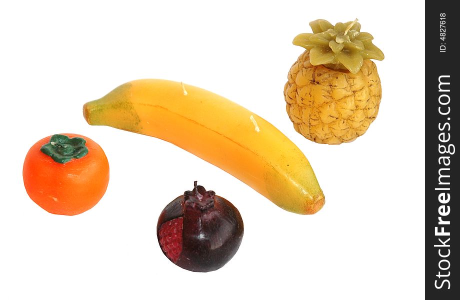 Four candles in the form of fruit a banana a pomegranate pineapple a persimmon