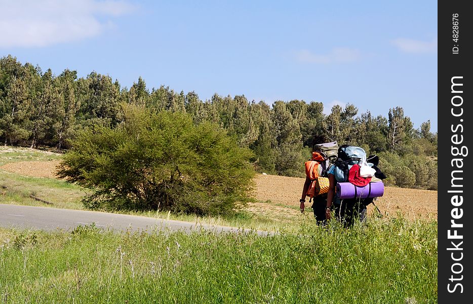 Summer travelers walking on a road