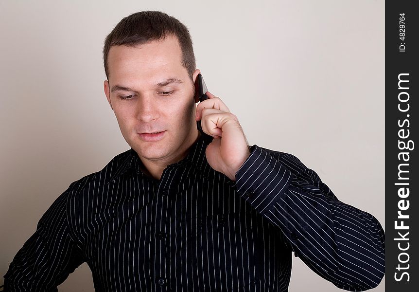 Young businessman talking on a mobile phone. Young businessman talking on a mobile phone