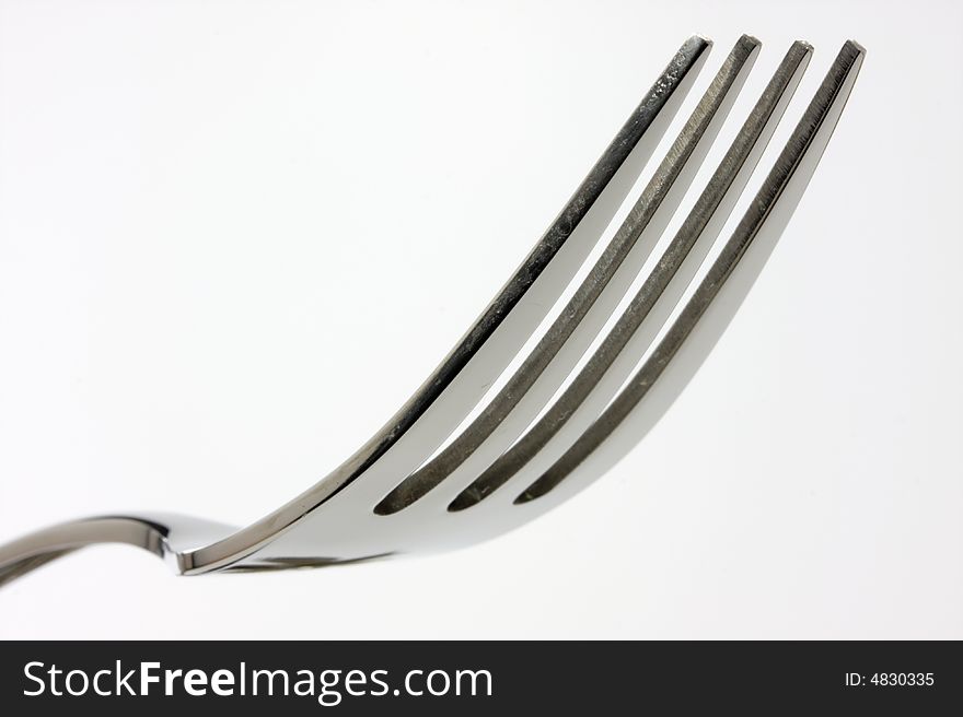 A closeup of a fork on white background