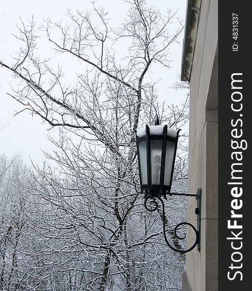Exterior wall lamp collecting snow as snow falls. Exterior wall lamp collecting snow as snow falls