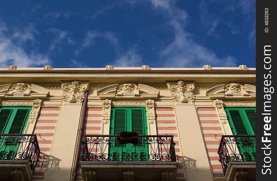 Classic italian facade with cute balconies defined against the blue sky. Classic italian facade with cute balconies defined against the blue sky