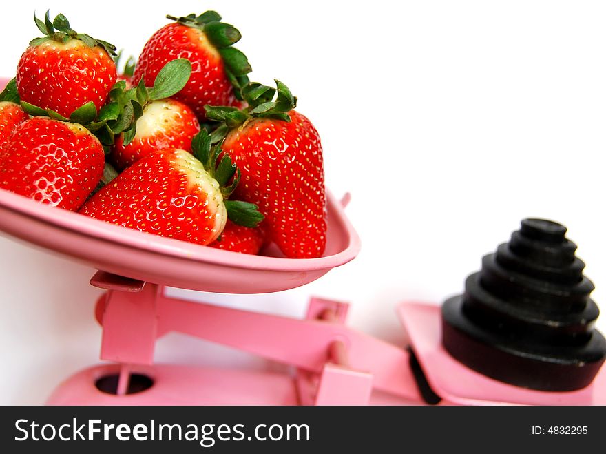 Strawberries in pink weighing scales. Strawberries in pink weighing scales