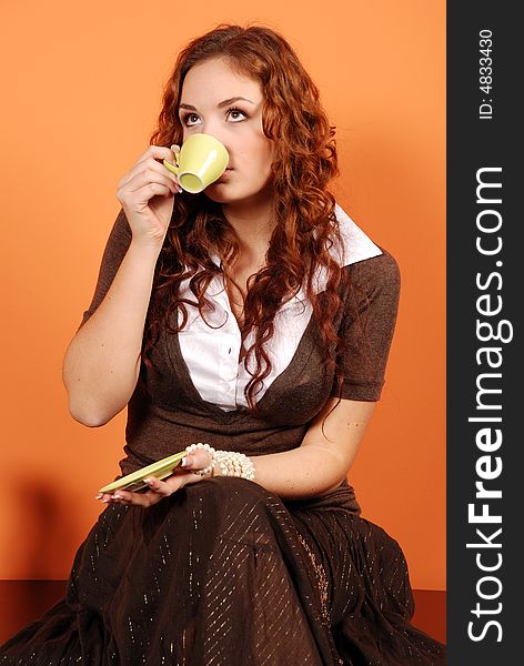 Young woman drinking coffee from green cup