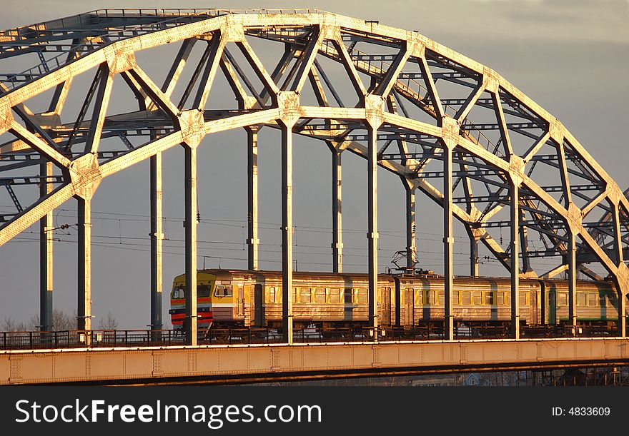 Morning train on the bridge across the Daugava river.