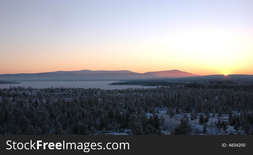 Sunrise in the winter morning above lake among mountains of Scandinavian peninsula. Sunrise in the winter morning above lake among mountains of Scandinavian peninsula