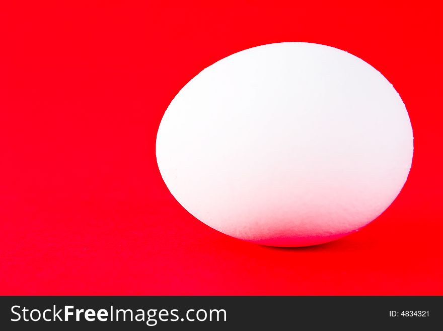 White egg on a red background