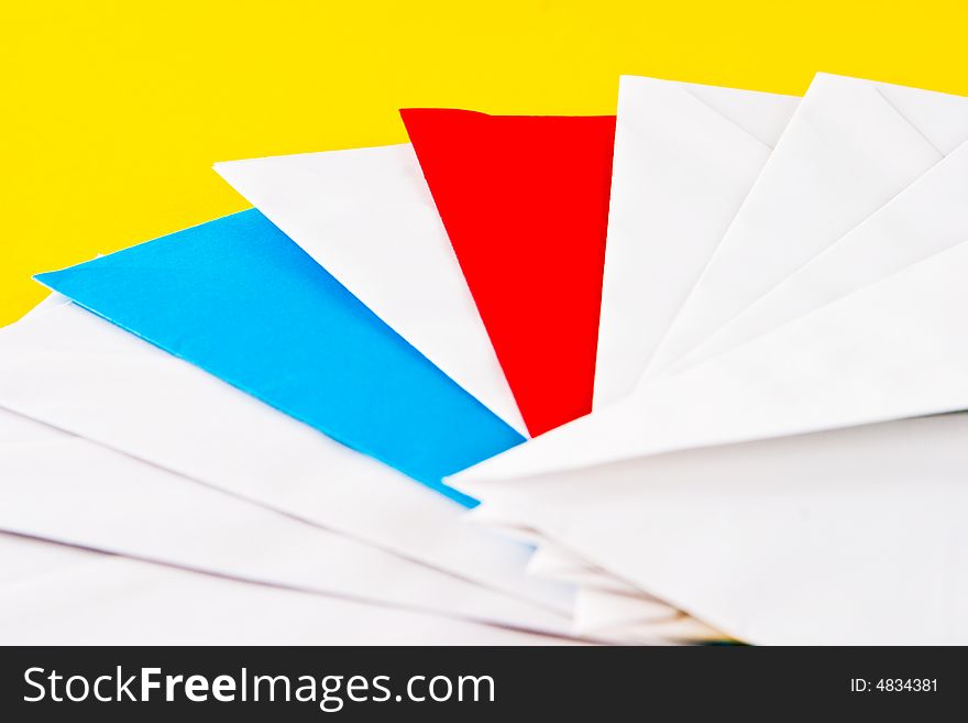 One red, one blue  and eight white envelopes on a yellow background. One red, one blue  and eight white envelopes on a yellow background