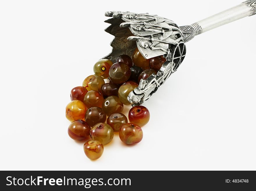 Amber beads, framing metal bas-relief isolated on white background. Amber beads, framing metal bas-relief isolated on white background