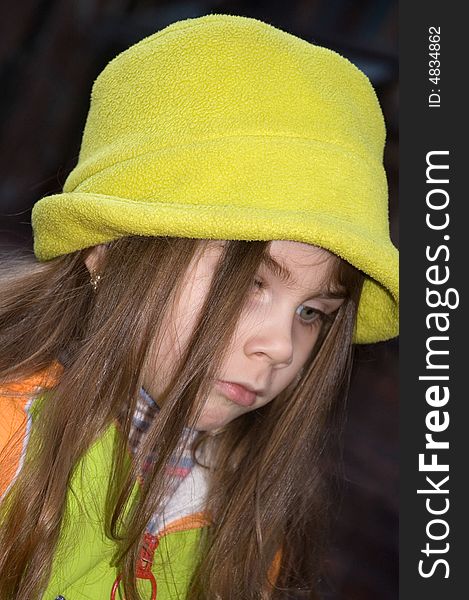 Little pretty thoughtful girl wearing a green hat. Little pretty thoughtful girl wearing a green hat