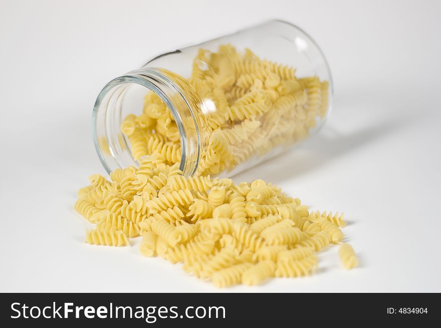 Italian fusilli pasta falling out of a glass jar