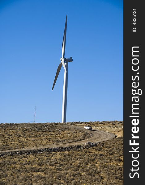 Pickup truck beneath wind turbines in the desert. Pickup truck beneath wind turbines in the desert