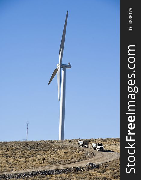 Dump truck beneath wind turbines in the desert. Dump truck beneath wind turbines in the desert