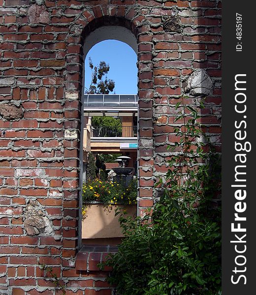 Window in a brick wall, with fountain in the background. Window in a brick wall, with fountain in the background.