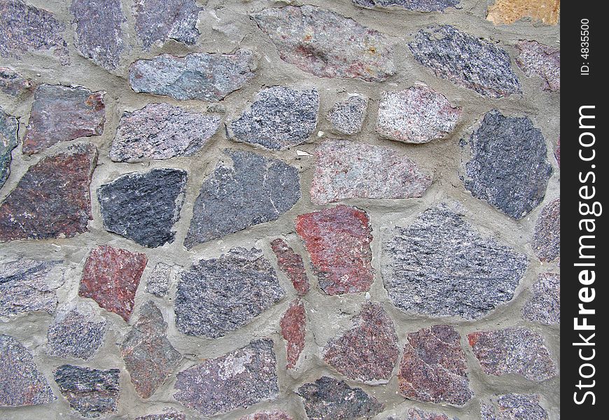 Wall from the varicoloured granite of clamped by cement solution. Wall from the varicoloured granite of clamped by cement solution