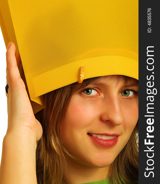 A pretty blond girl put a yellow shopping bag on her head. A pretty blond girl put a yellow shopping bag on her head